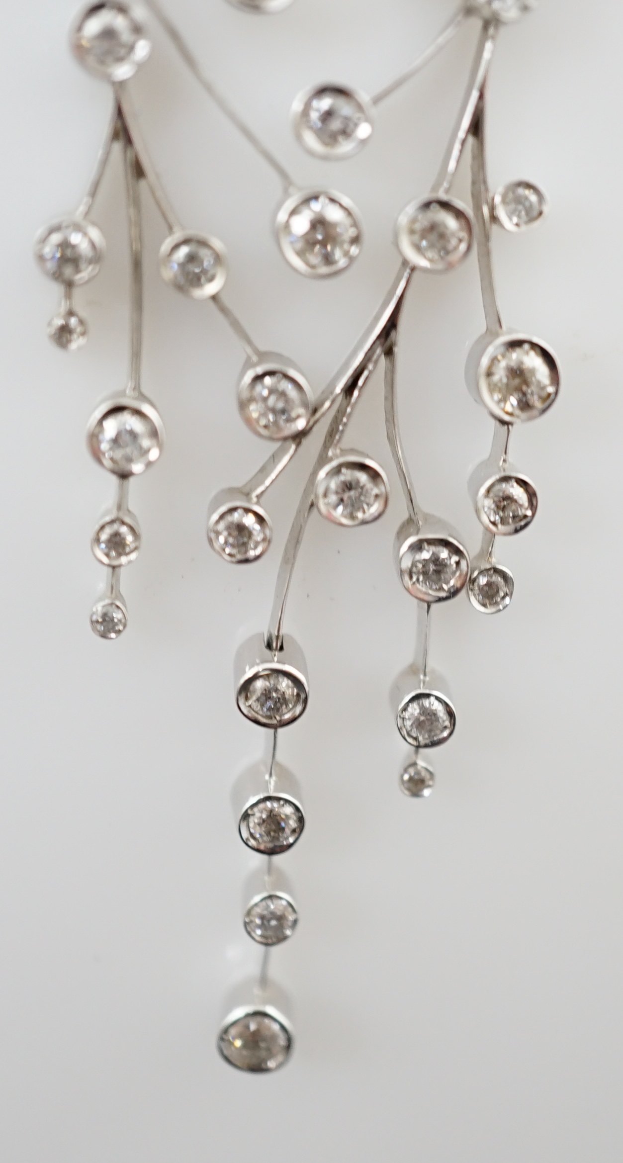 A modern 18ct white gold and diamond cluster set drop pendant on chain, together with a pair of matching drop earrings